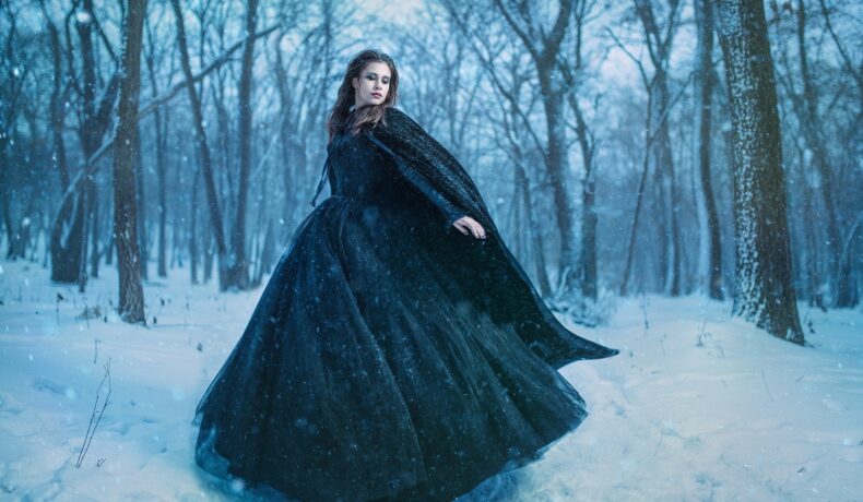 O femeie frumoasăc are poartă o rochie neagră și se află într-o pădure acoperită cu zăpadă pentru a reprezenta una din cele trei zodii ghinioniste în ziua de 26 ianuarie 2022