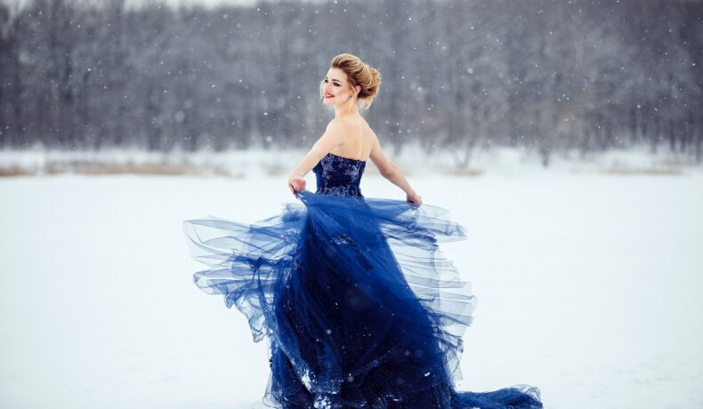 O femeie frumoasă care poartă o rochie albastră pe un câmp acoperit cu zăpadă pentru a reprezenta una din cele trei zodii norocoase în ziua de 6 ianuarie 2022
