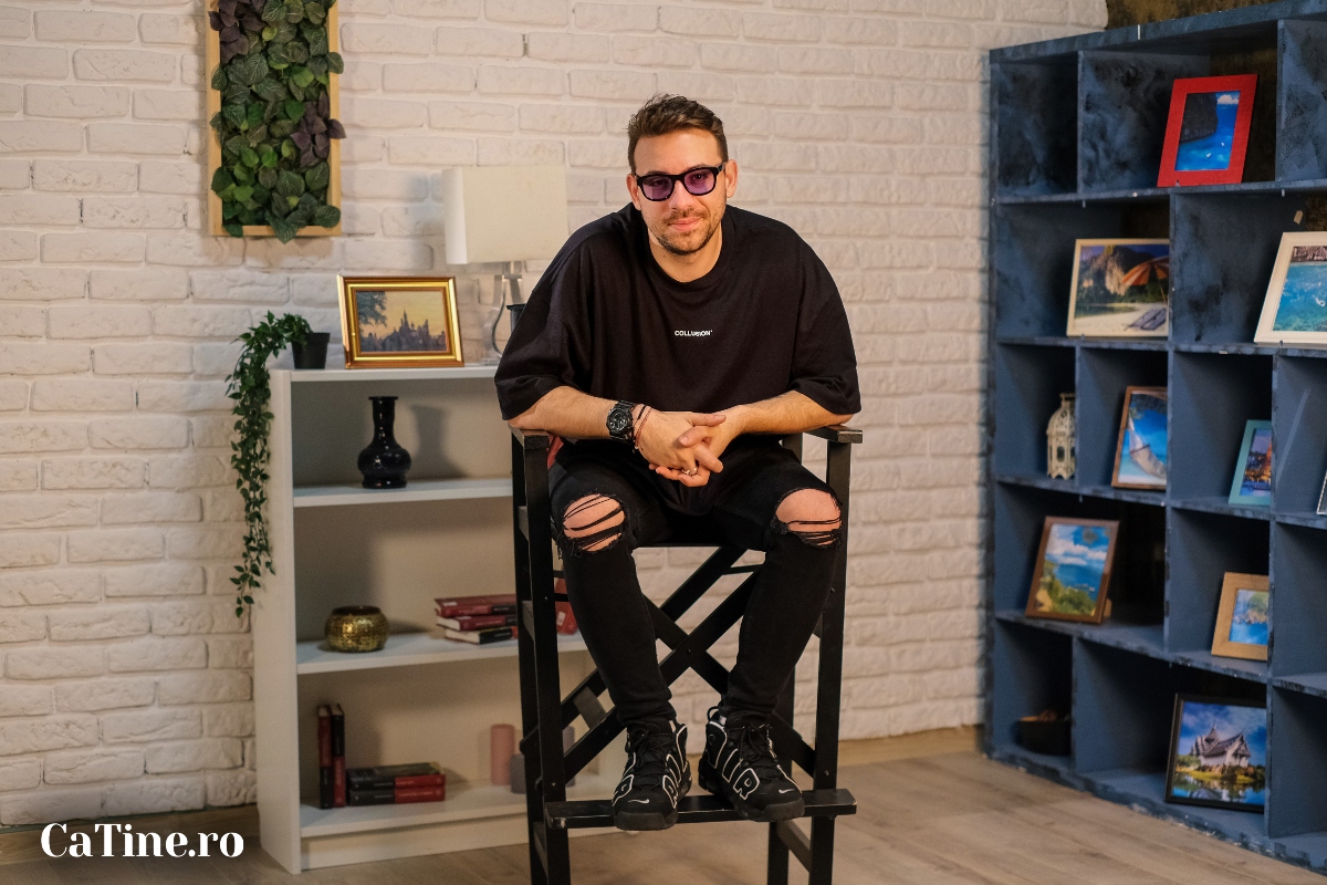 Andrei Niculae, cu mâinile împreunate, îmbrăcat în negru, la interviul CaTine.ro
