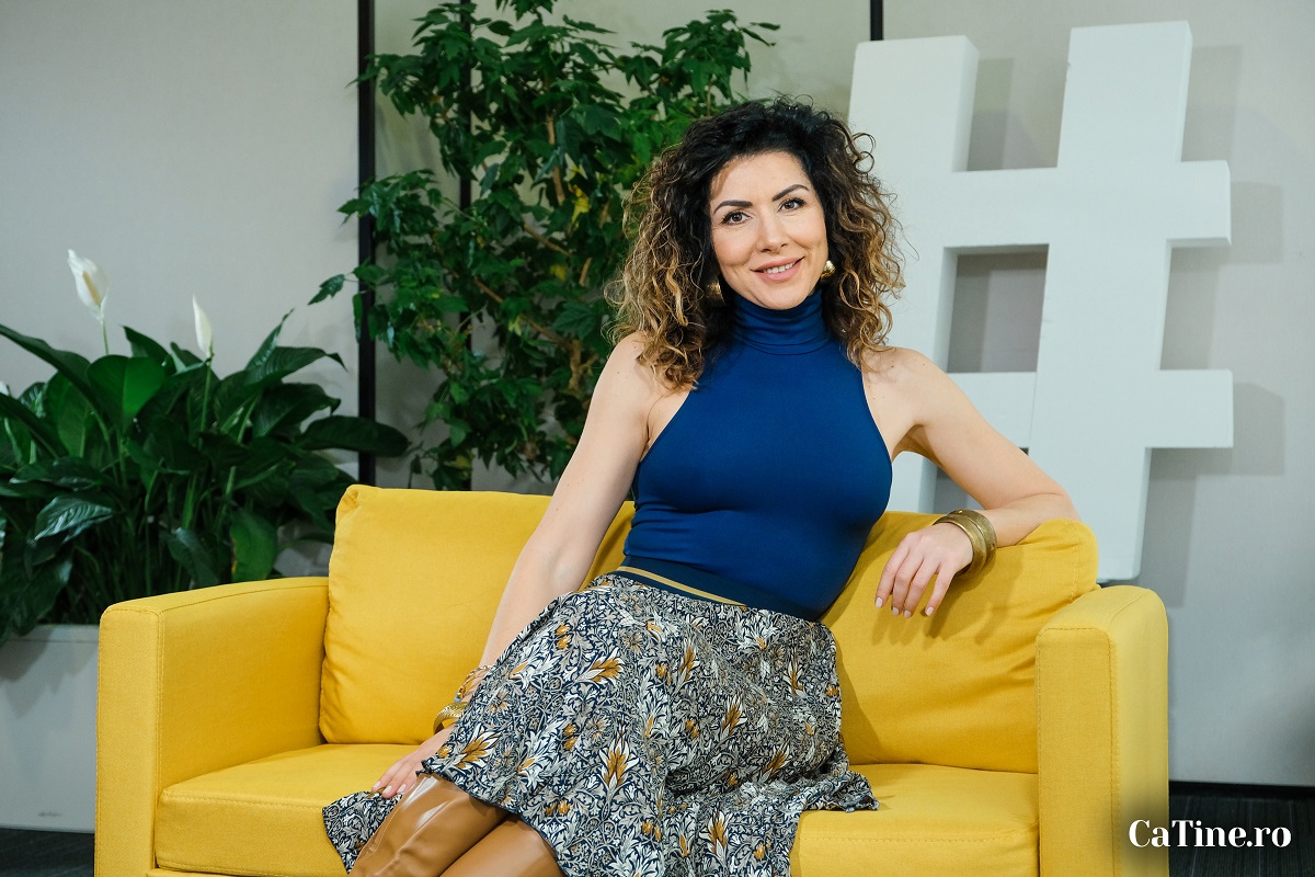 Carmen Brumă în timp ce stă pe o canapea galbenă la interviul pentru CaTine.ro