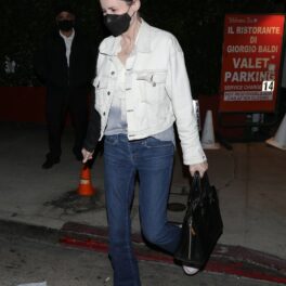 Geena Davis, într-o geacă albă și jeanși, pe stradă