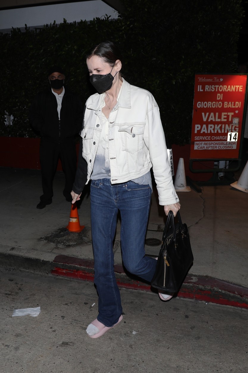 Geena Davis, într-o geacă albă și jeanși, pe stradă