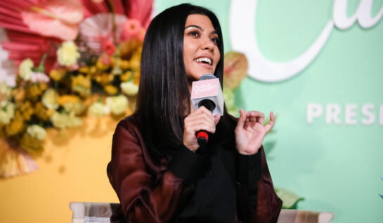 Kourtney Kardashian, la o conferință de presă, în timp ce explică ceva