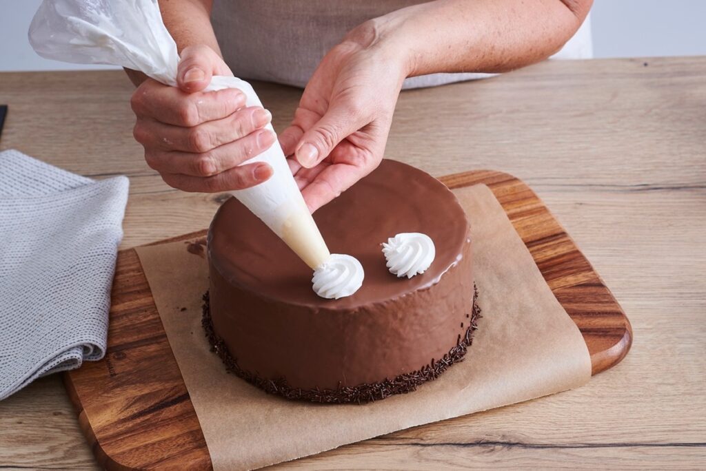 A step-by-step picture of decorating a mosaic cake with cream