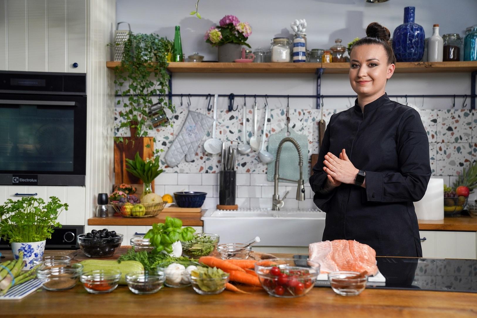 Roxana Blenche, fotografiată cu multe legume pe masă, în timp ce se pregătește să gătească