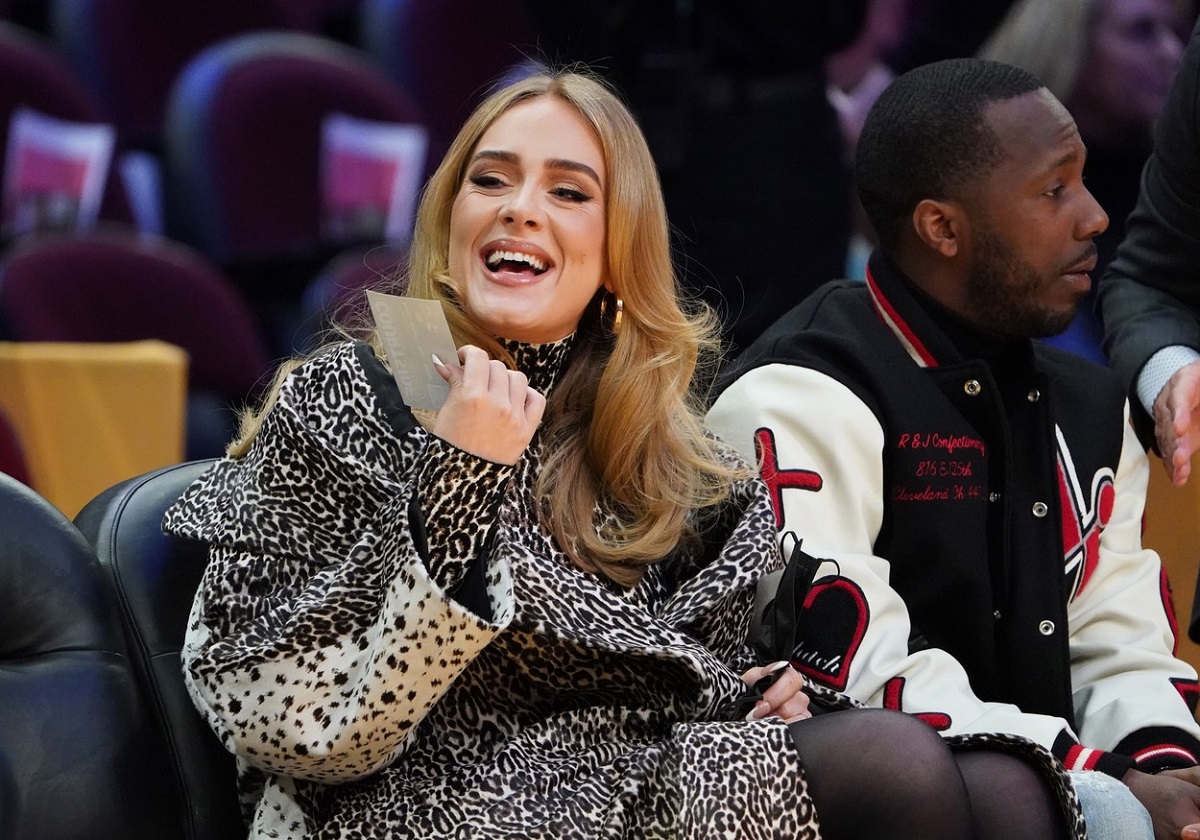 Adele, îmbrăcată într-o haină cu imprimeu de leopard în timp ce stă alături de Rich Paul la un mechi de baschet din Cleveland