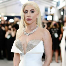 Lady Gaga într-o rochie albă armani în timp ce pozează pe covorul roșu de la SAG Awards 2022
