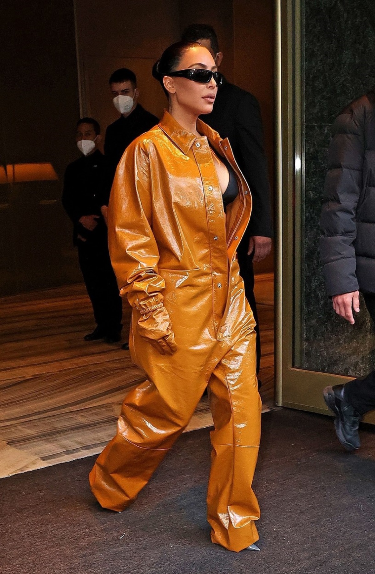 Kim Kardashian într-un costum de piele portocaliu în timp ce părăsește un hotel din Milano