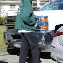 Pete Davidson într-un hanorac verde în timp ce urcă în mașina lui Kim Kardashian