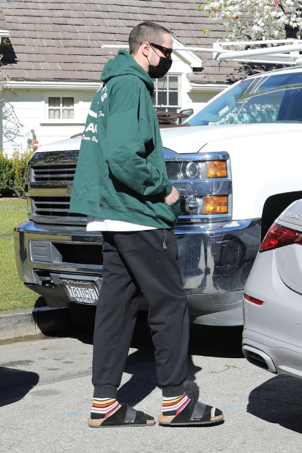 Pete Davidson într-un hanorac verde în timp ce urcă în mașina lui Kim Kardashian