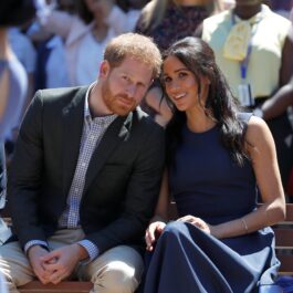 Prințul Harry îmbrăcat la cstum alături de soția sa, Meghan MArkle la un eveniment public