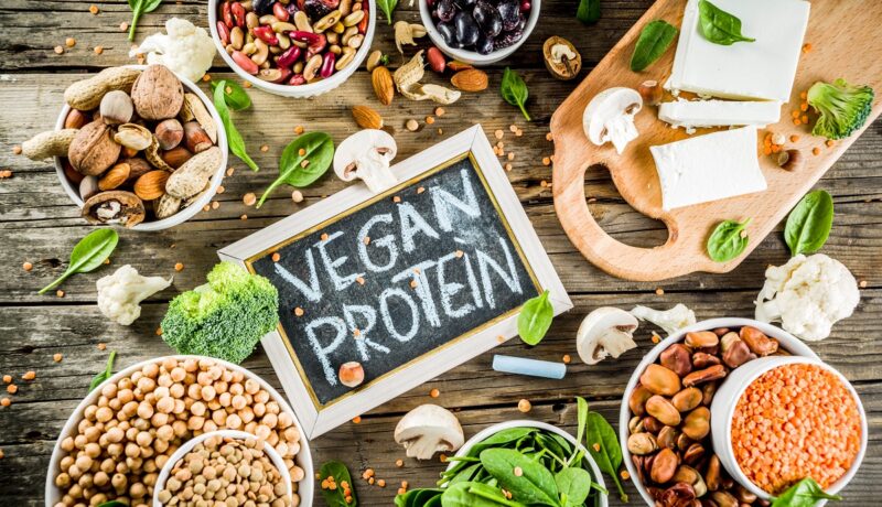 Un blat de lemn pe care se află tofu, semințe de cânepă, nuci și alte surse de proteine pentru persoanele vegetariene și vegane