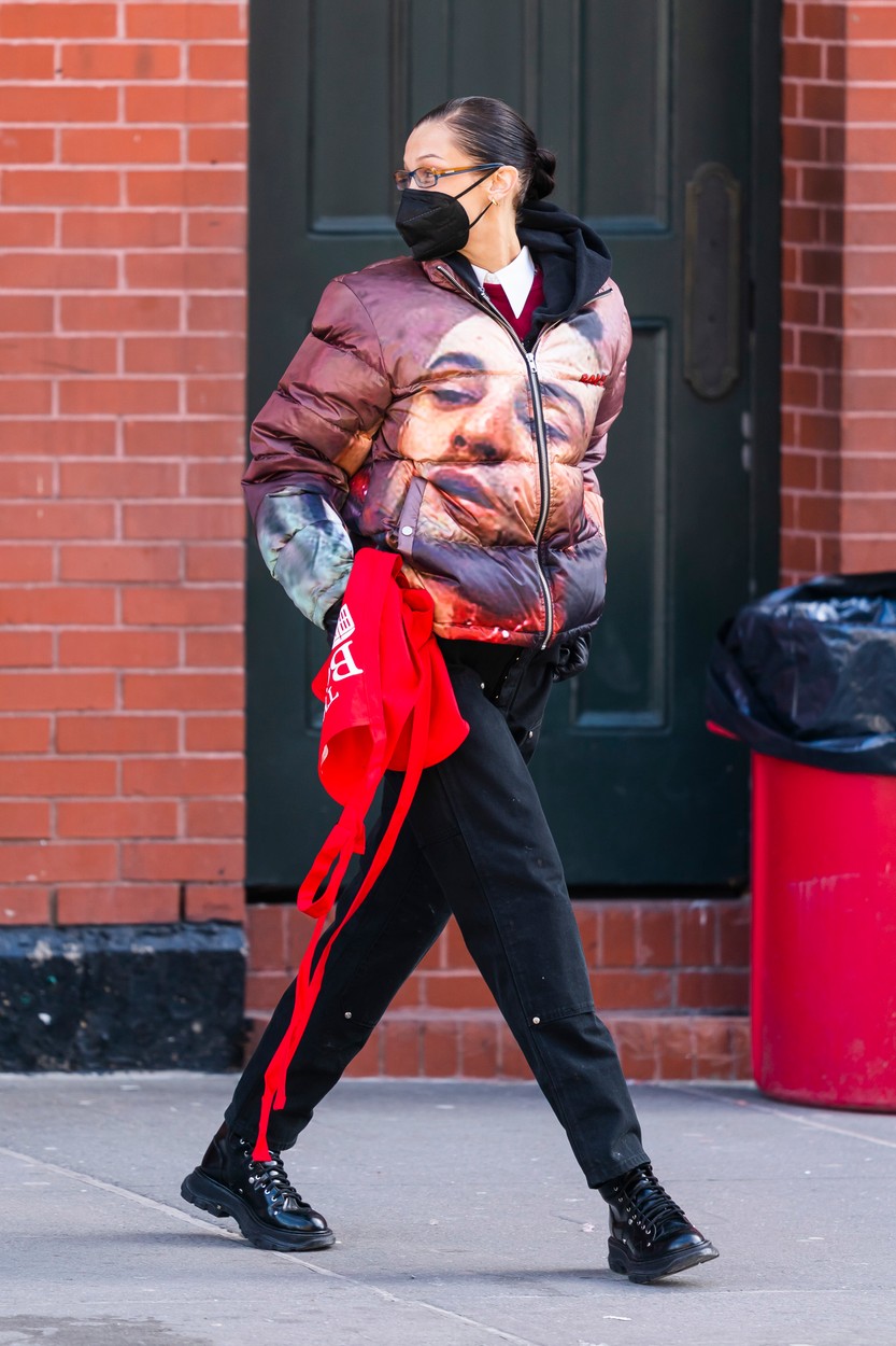 Bella Haid, fotografiată pe stradă cu un șorț roșu în mână