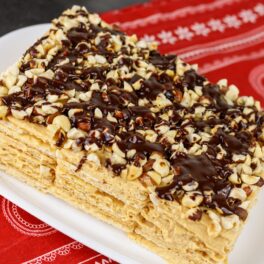 Prăjitură din foi de napolitane cu cremă caramel și glazură de ciocolată cu alune de pădure