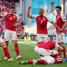 Christian Eriksen, căzut pe terenul de fotbal, cu colegi în jur care încearcă să vadă ce a pățit