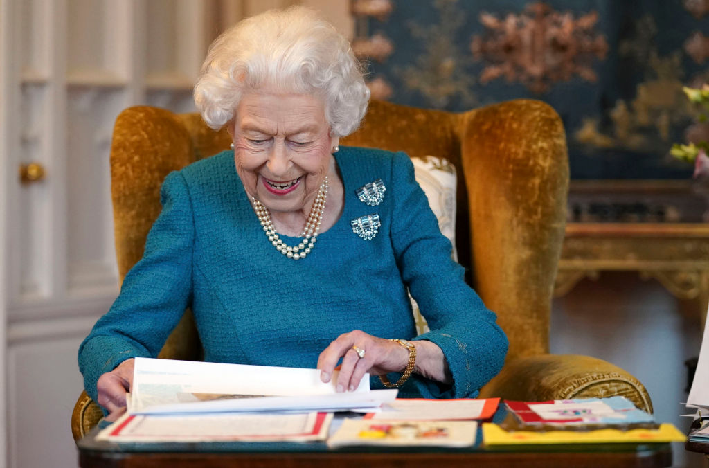 Regina Elisabeta, la birou, fotografiată în timp ce semnează niște acte