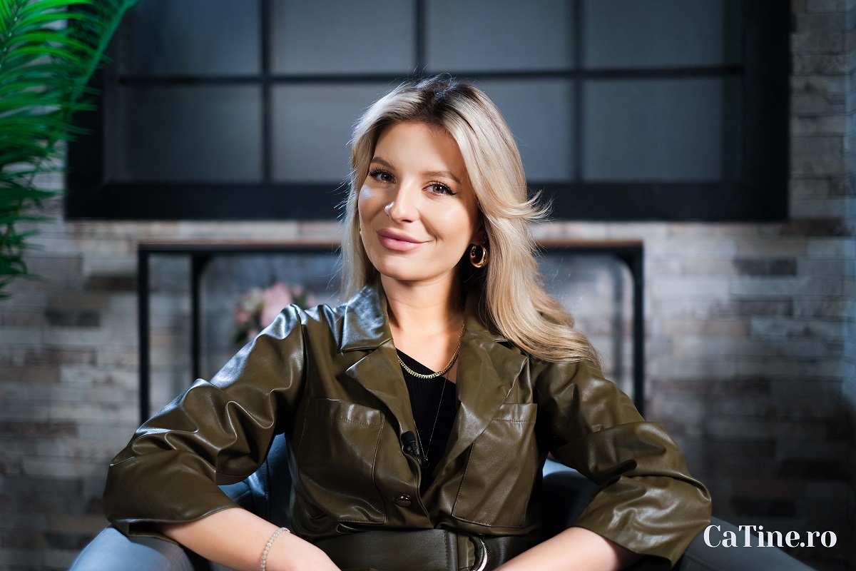 Ana Baniciu purtând o jachetă verde în timp ce stă pe un fotoliu și pozează pentru interviul echipei CaTine.ro