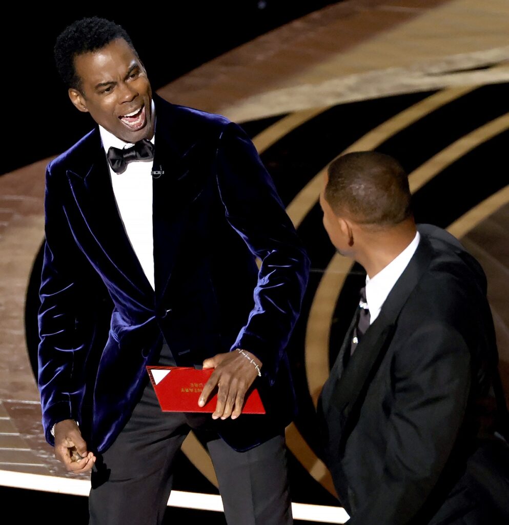 Chris Rock pe scenă la Premiile Oscar în timp ce este lovit de actorul Will Smith