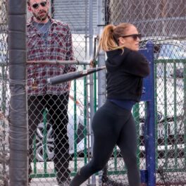 Jennifer Lopez în timp ce joacă baseball și poartă un trening negru