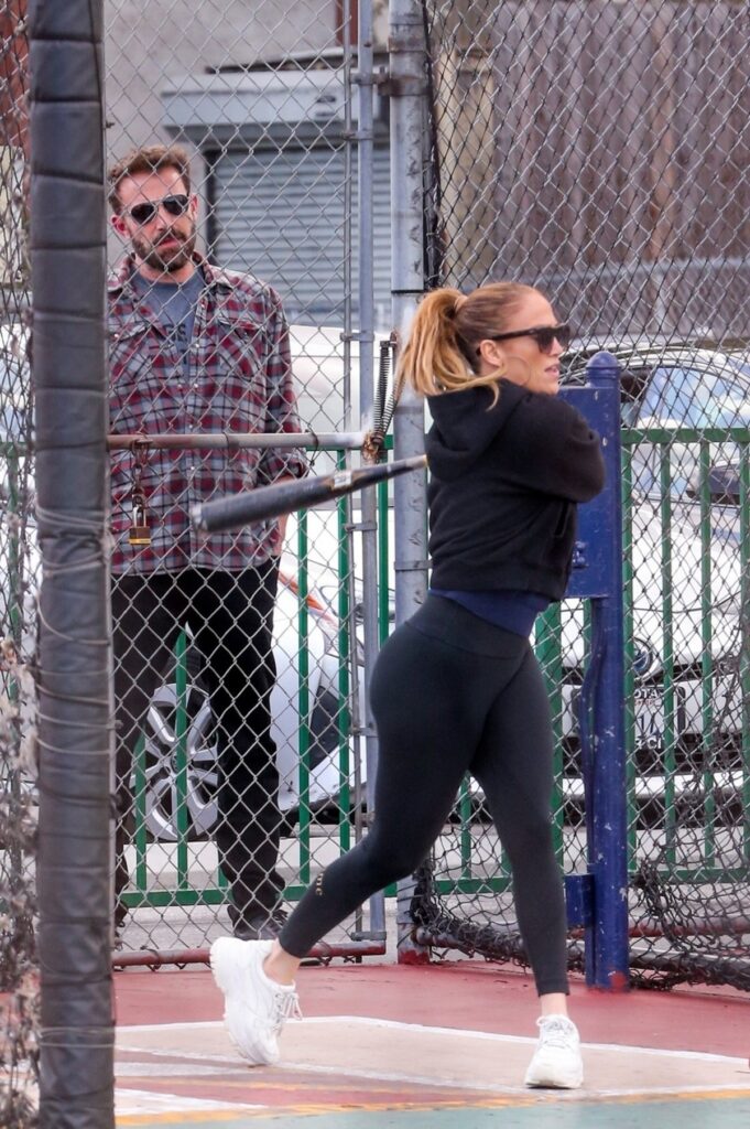 Jennifer Lopez în timp ce joacă baseball și poartă un trening negru