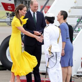 Kate Middleton într-o rochie galbenă alături de Prințul William îmbrăcat la costum în timpc e vcoboraă din avion pentru ase întâlni cu oficialii din Jamaica