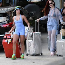 Lourdes Leon într-un costum creat de Kim Kardashian în timp ce trage după ea o valiză roșie