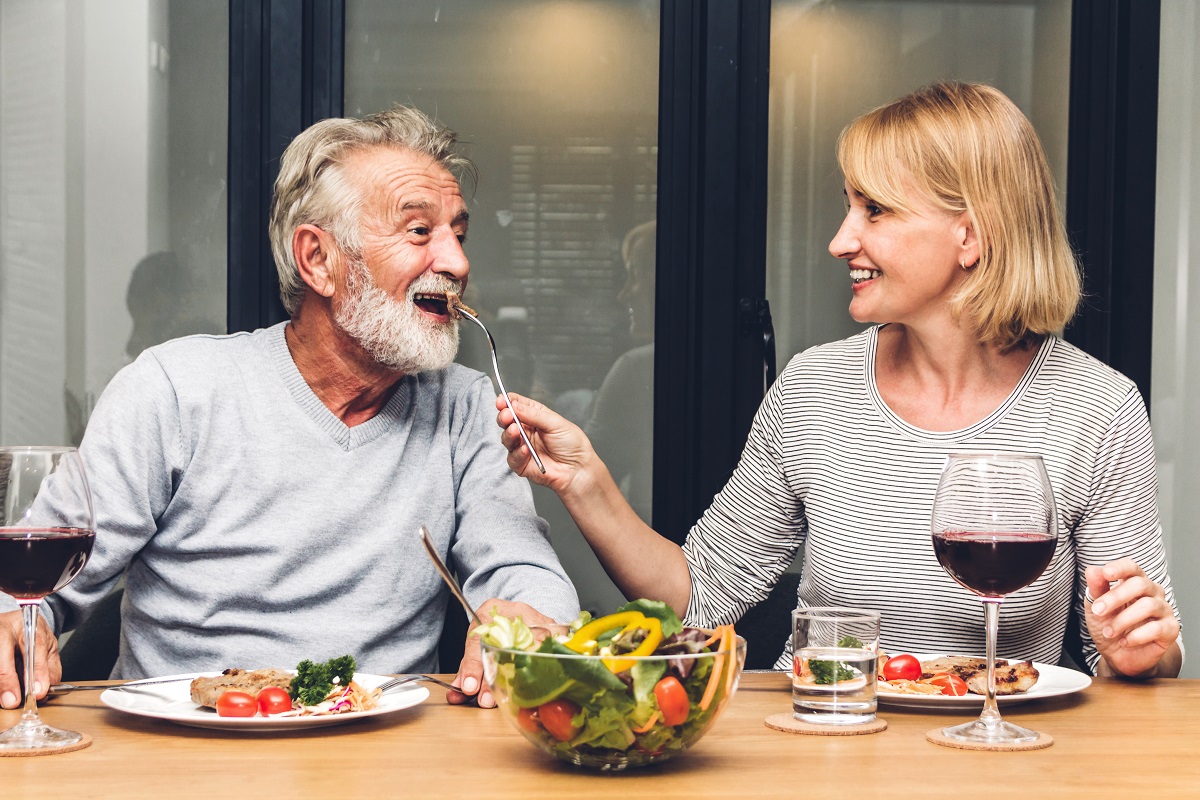 Un cuplu cu un domn în vârstă și o doamnă care iau masa împreună pentru a ilustra obiceiul care îți afectează silueta atunci când înaintezi în vârstă