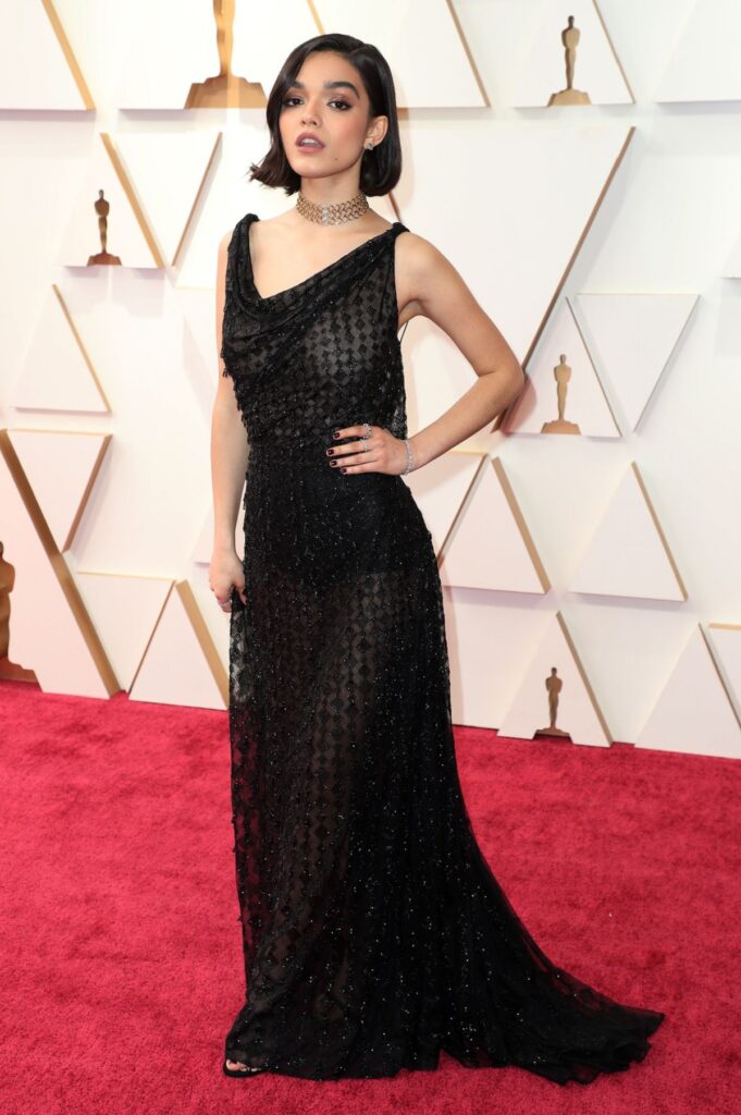 Rachel Zegler într-o rochie lungă și neagră în timp ce pozează pe covorul roșu de la Gala Premiilor Oscar 2022