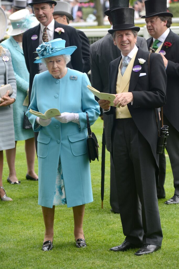 Regina Elisabeta alături de consilierul său pentru cursele de cai John Warren la o întâlnire oficială din anul 2014