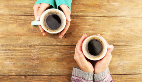 Două femei care își beau cafeaua împreună, după amiaza