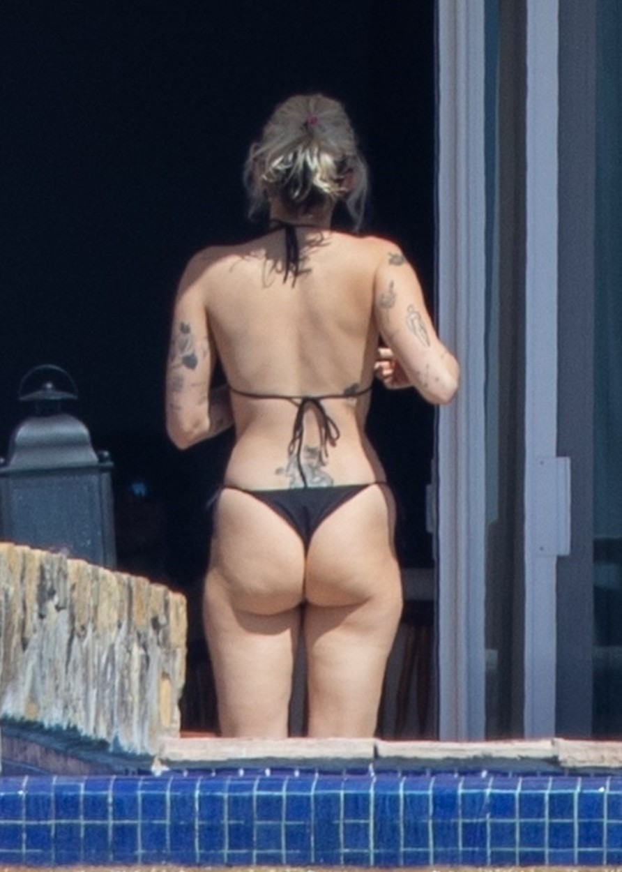 Miley Cyrus, cu posteriorul la vedere, într-un costum de baie negru, din două piese