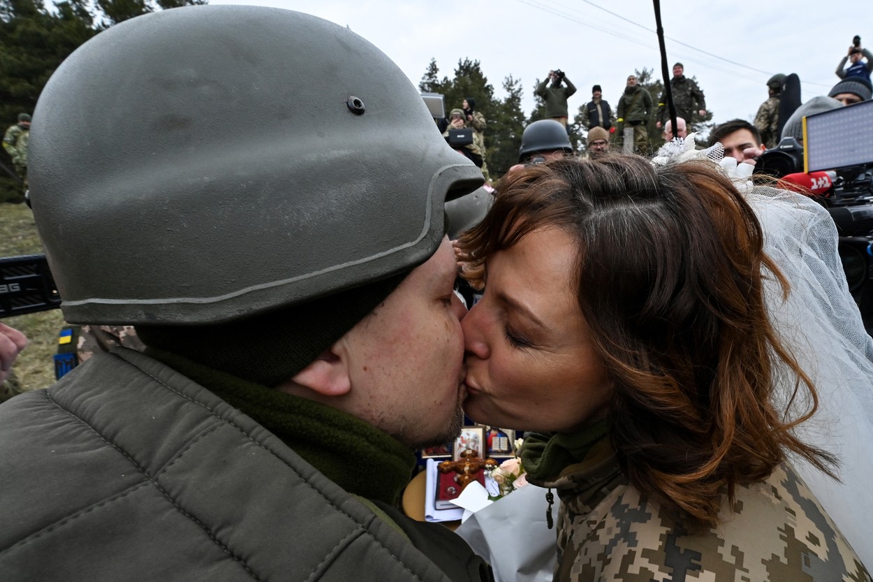 Mire și mireasă care se sărută după ce s-au căsătorit pe frontul de luptă