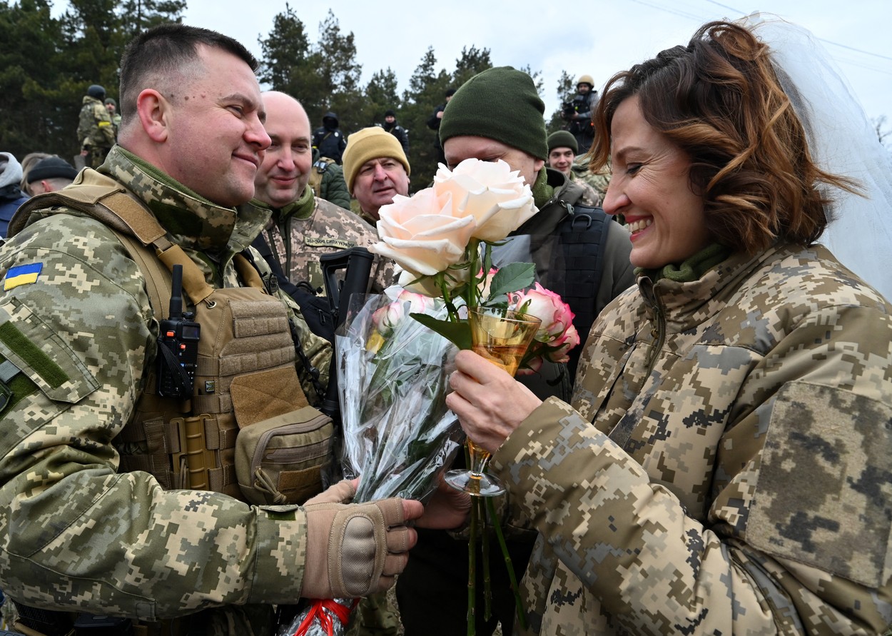 Mireasa este zâmbitoare în ziua nunții sale, chiar dacă evenimentul are loc în prima linie a războiului