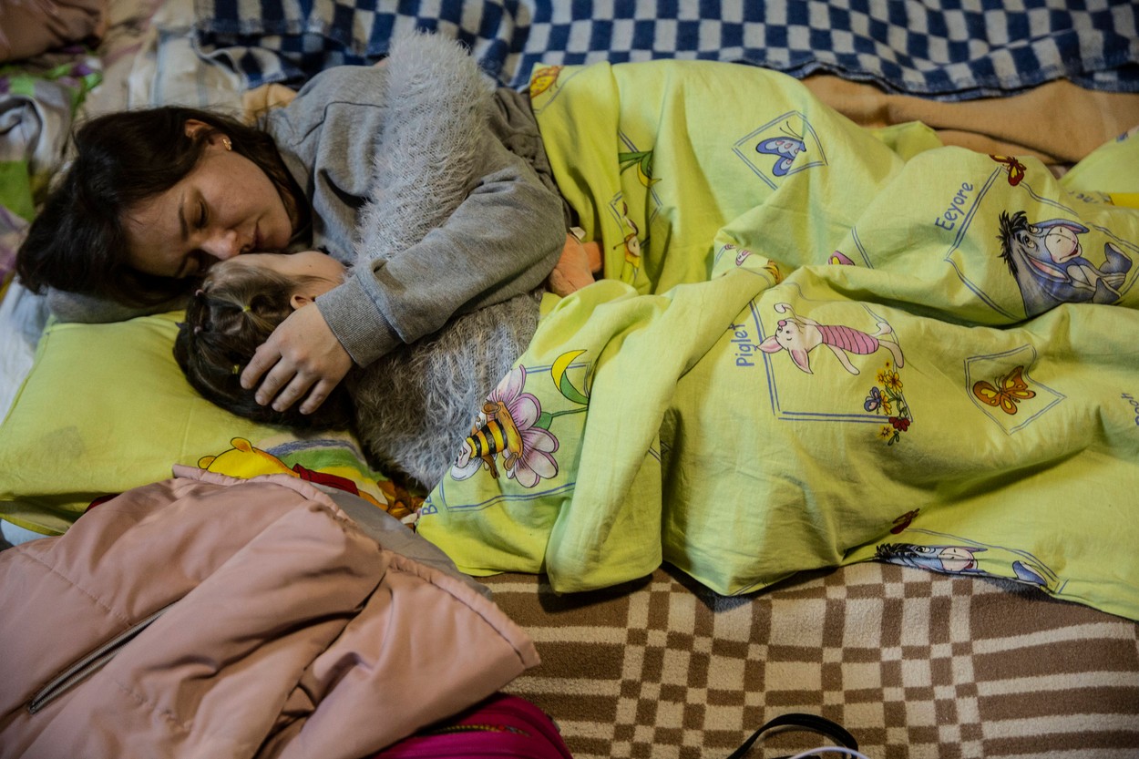 O mamă care își ține copilul în brațe într-un spital improvizat în Ucraina