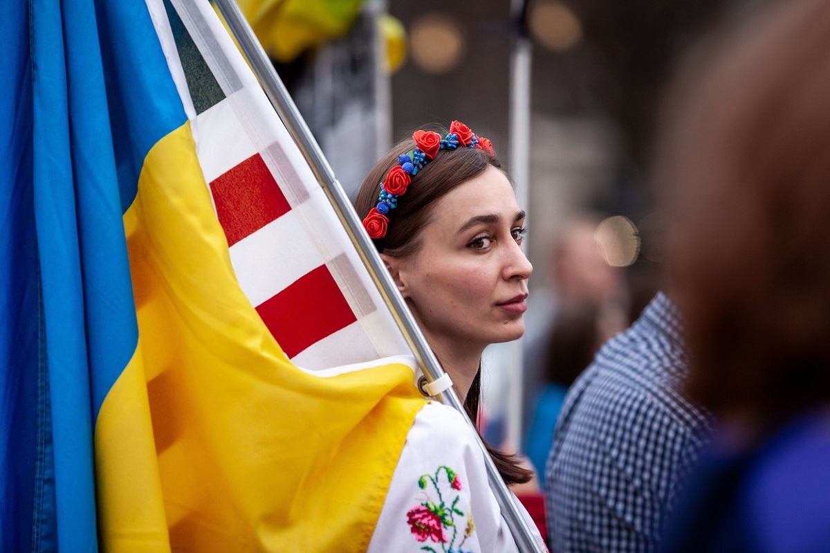 O femeie care ține steagul ucrainei în timp ce protestează pentru încetarea războiului