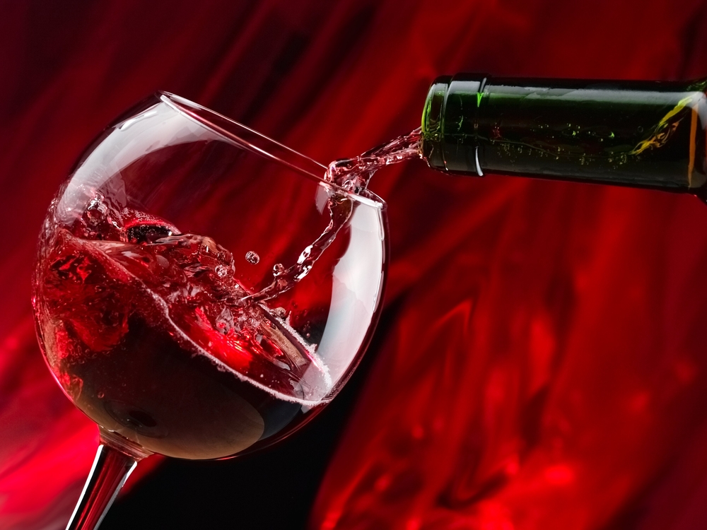 Un pahar de vin roșu, pe un fundal roșu