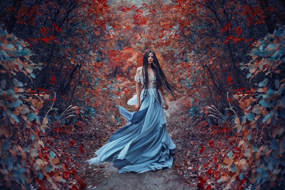 O femeie frumoasă într-o rochie albastră care se află într-o pădure pentru a reărezenta cele trei zodii ghinioniste în ziua de 19 martie 2022