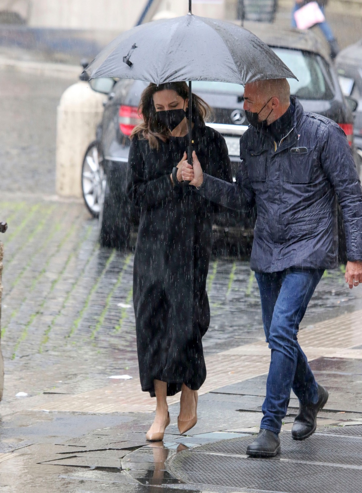 Angelina Jolie a purtat o rochie neagră în Roma și a stat alături de un bărbat care i-a ținut umbrela în timp ce aceasta a încercat să se ferească de ploaie