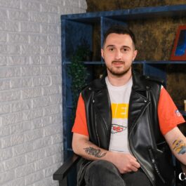 Augustin Zainea într-o jachetă din piele în timp ce ia parte la interviul la masculin al elchipei CaTine.ro