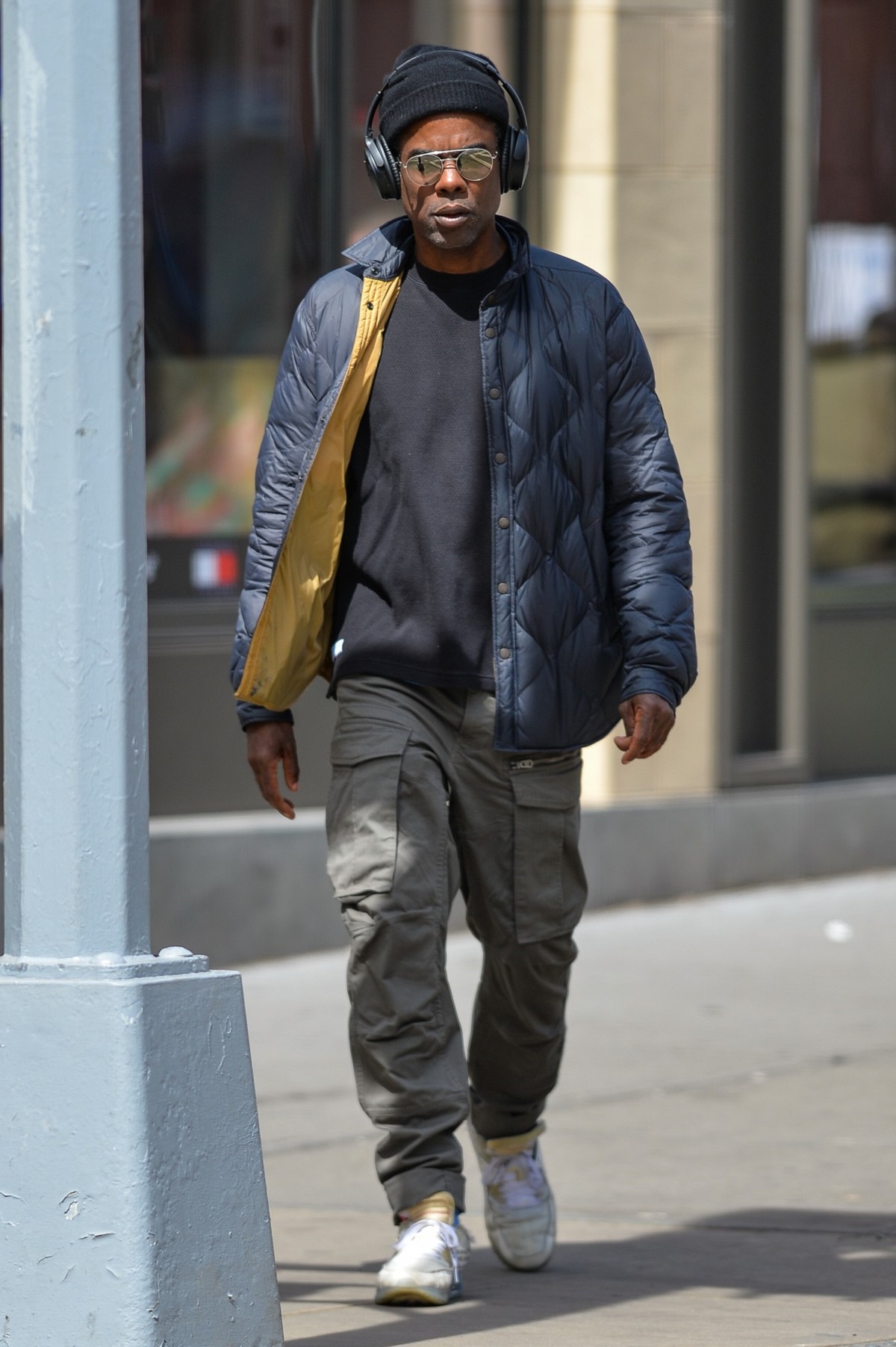 Chris Rock îmbrăcat într-un tricou negru și o jachetă albastră în timp ce se plimbă pe străzile din New York