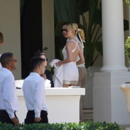 Nicola Peltz într-o rochie mulată albă în timp ce vorbește cu invitații de la nunta sa