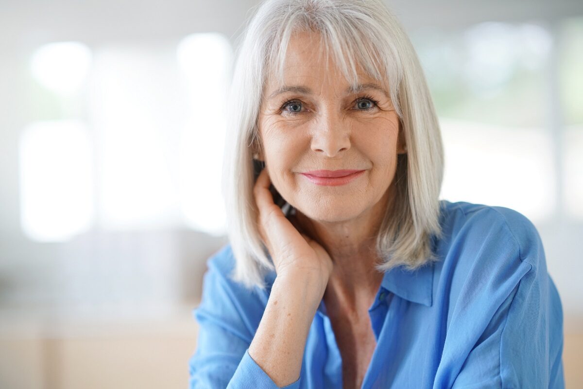 Ofemeie frumoasă cu bluza albastră care vorbește despre obiceiuri sănătoase care te pot ajuta după vârsta de 50 de ani