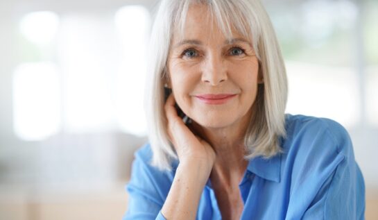 Ofemeie frumoasă cu bluza albastră care vorbește despre obiceiuri sănătoase care te pot ajuta după vârsta de 50 de ani