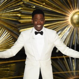 Chris Rock îmbrăcat la un costum alb în timp ce prezintă la Gala Premiilor Oscar din 2016