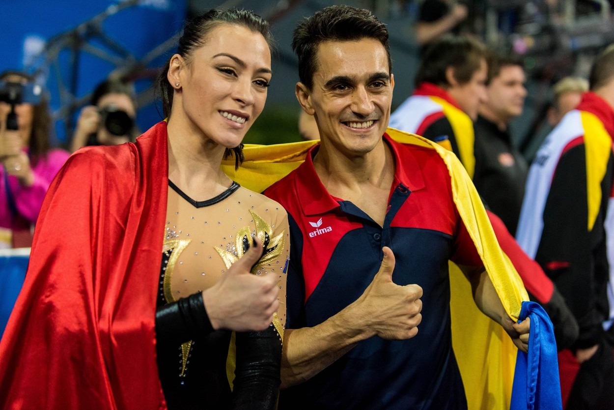 Cătălina Ponor și Marian Drăgulescu, la o competiție sportivă, cu drapelul pe umeri