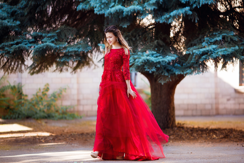 Fată frumoasă îmbrăcată în rochie lungă, roșie