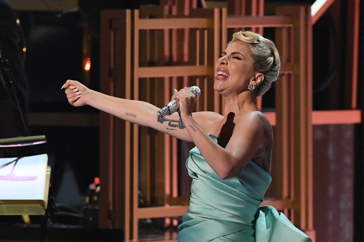 Gaga, cu microfonul în mână, în timp ce cântă