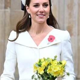 Kate Middleton, cu un buchet de flori în mână, într-o rochie albă