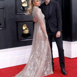 Paris Hilton într-o rochie argintie și Carter Reum pe covorul roșu la premiile grammy 2022