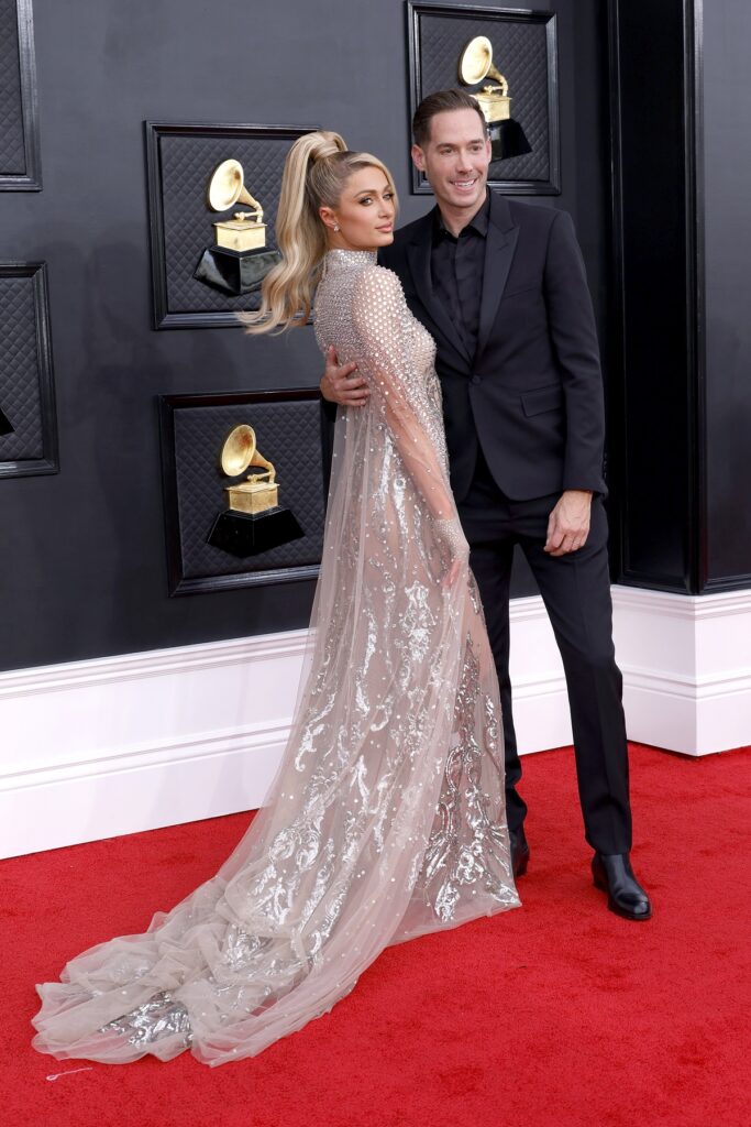 Paris Hilton într-o rochie argintie și Carter Reum pe covorul roșu la premiile grammy 2022